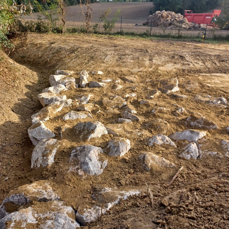 Un chantier avec de la terre et des gros cailloux